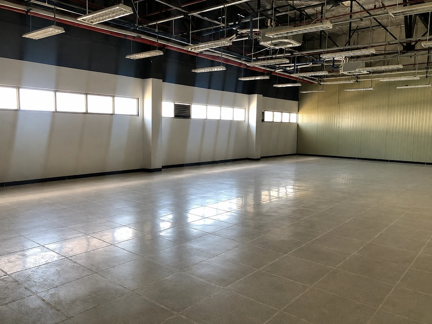 Corner view of a completed ESD tile floor reflecting overhead industrial lighting